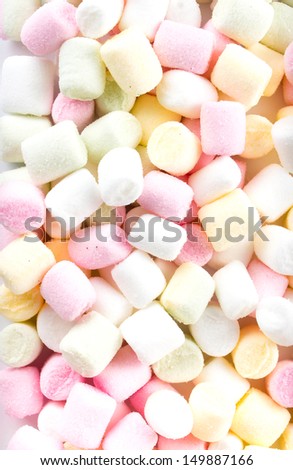 A pile of small colored puffy marshmallows may use as background. Close up, top view