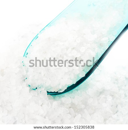 Crystal Sea Salt in cyan scoop spoon on white background closeup