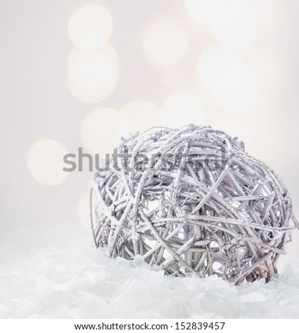 Christmas composition with silver bauble and snow  on Defocused Christmas Bokeh silver background with snowflakes