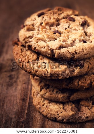 Stacked chocolate chip cookies on wooden background. Chocolate chip cookies shot with selective focus.