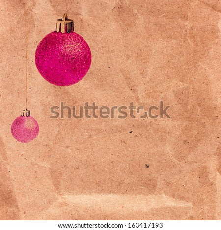 Vintage Christmas card with glittering balls on old recycled brown paper  with copy space. Christmas decoration over grunge vintage paper background.