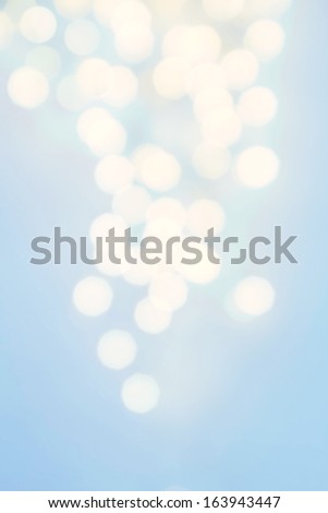 Defocused Holiday Bokeh twinkling lights Vintage background with white lights in bright blue color.