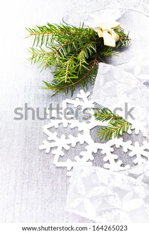 Christmas tree branch and White Christmas decorations on soft grey background. Christmas Time card.