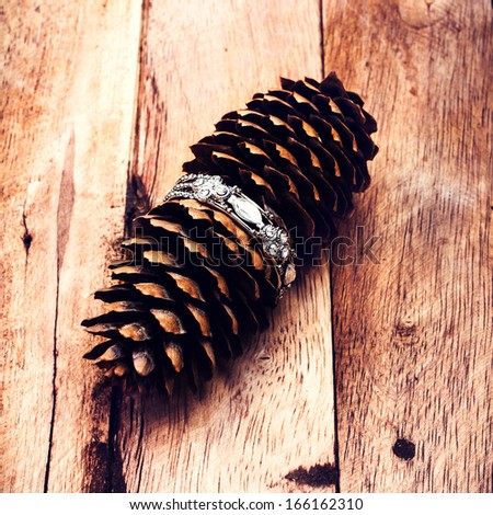 Christmas pine cone on wooden background with decorations. Christmas card on wood board. Vintage rustic style.