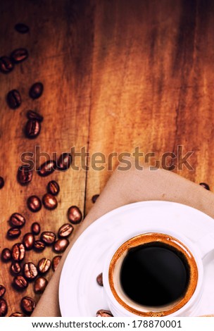 Coffee cup and roasted coffee beans  on wooden  brown background with copyspace for text. Coffee  on a wooden table, top view.
