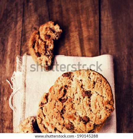 Chocolate cookies on white linen napkin on wooden table. Chocolate chip cookies shot on white table cloth, closeup.