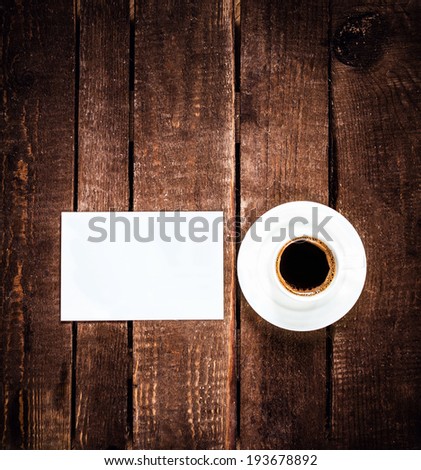 Coffee cup and blank business card on wooden table with copy space. White Card for text and Coffee Espresso over wood background closeup.