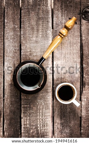 Black  Coffee cup and Coffee pot over wood table top view. Inspirational early morning breakfast.