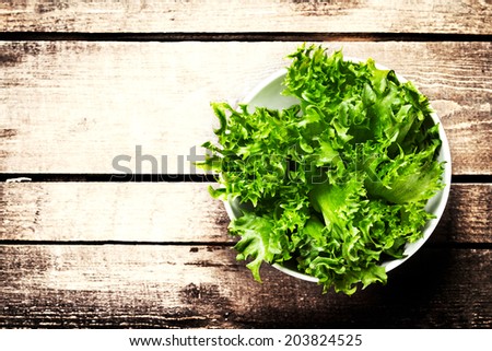 Fresh green salad in a bowl on  wooden background - Lettuce Salad background with copyspace. Healthy or vegetarian food concept.