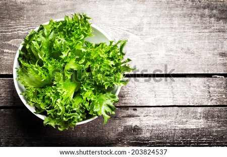 Fresh green salad in a bowl on  wooden background - Lettuce Salad background with copyspace. Healthy or vegetarian food concept.