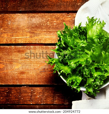 Fresh green salad in a dish over wooden background. Diet Food and healthy lifestyle concept. Lettuce Salad background