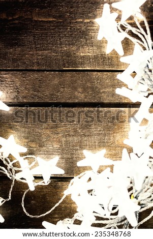 Christmas background with lights, snowflakes, stars and free text space. Festive vintage planked wood with copyspace
