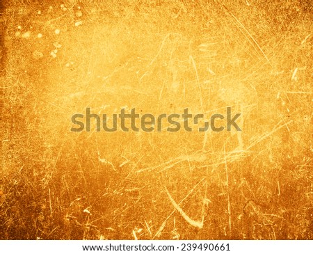 Abstract gold textured  background with spotlight and scratches.