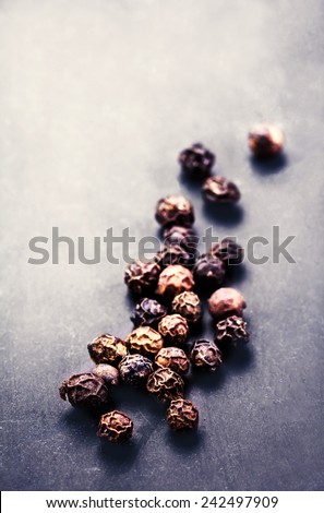 Black Peppercorns closeup.  Black pepper on dark  background with copyspace