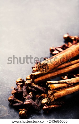 Spice background - various spices over dark table. Collection of different spices - cinnamon, black papper, anise star, peppercorns.