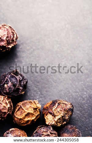 Black Peppercorns closeup. Black pepper on dark background with copyspace