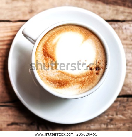 Cup of Coffee for breakfast on rustic wooden table, top view. Cappuccino over wooden background