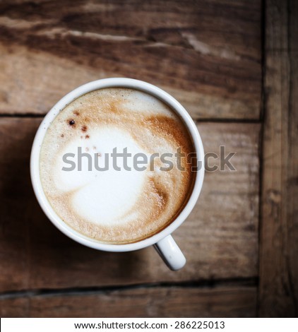 Cup of Coffee for breakfast on wooden table, top view. Cappuccino over wooden background
