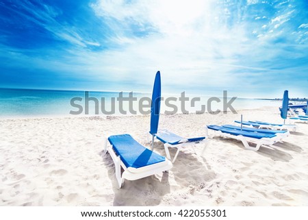 Perfect tropical paradise beach / Vacation holidays background wallpaper  with  beach lounge chairs and  tents
