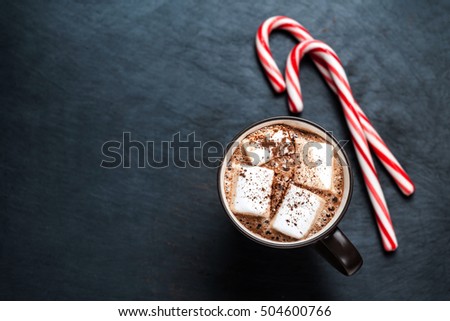Hot Chocolate with marshmallows and candy stick, traditional beverage for winter time,