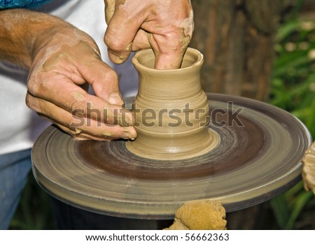 Potter working clay on potter's wheel