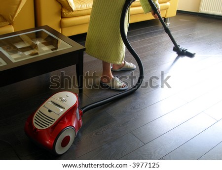Man with vacuum cleaner cleans the floor