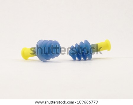 Two Blue and Yellow Rubber Earplug Used for Hearing Protection. Both laying on their side.