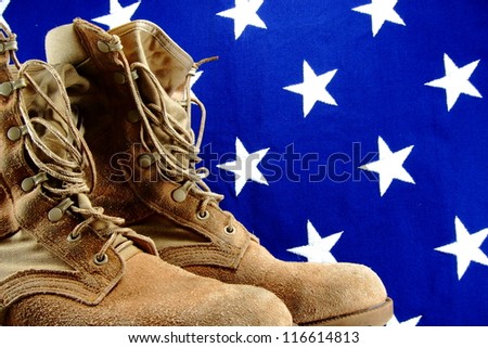 Desert military boots set against a vintage vivid cloth American flag