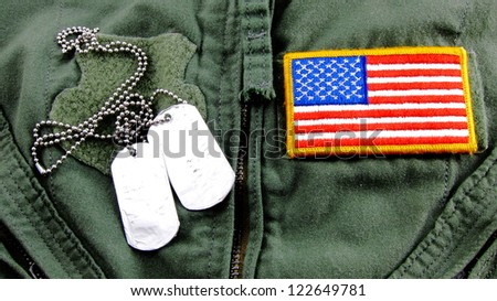 Military dog tags and American Flag patch on pilot flight suit