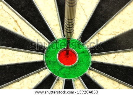 Single dart hitting the red center portion of a dart board