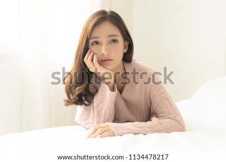 Woman indoor portrait. Young beautiful Asian woman in warm knitted pink clothes at home. fashion. Autumn, winter
