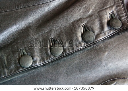buttons on the black leather vest