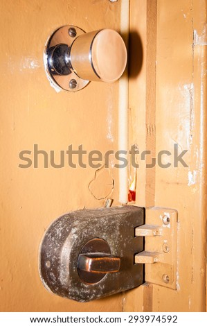 door lock and door handle on a yellow painted door