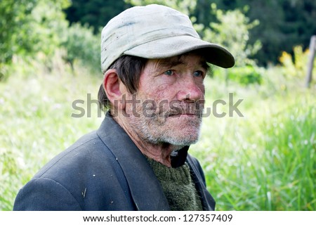 Beggar man stands and looks sad eyes