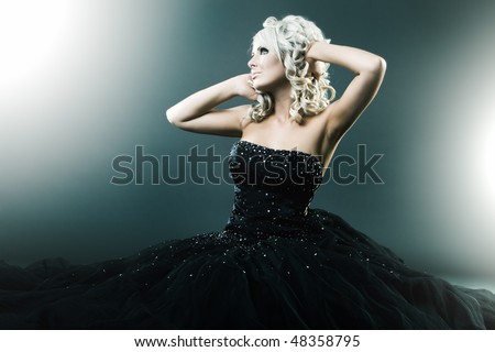 High fashion woman in sexy pose and  large formal dress