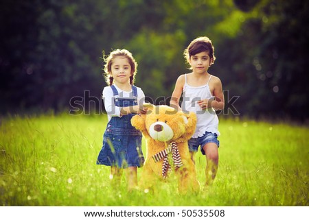 girls with teddy bears. tall grass with teddy bear