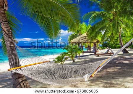 Hammock between palm trees on a vibrant tropical beach of Rarotonga, Cook Islands, South Pacific