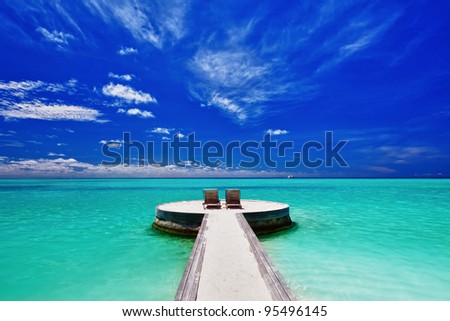 Two deck chairs on stunning empty tropical beach