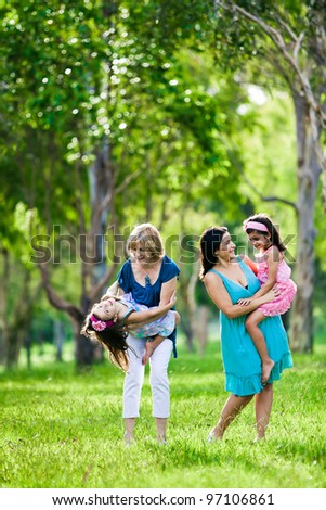 Mother, grandmother and daughters having laugh in the park