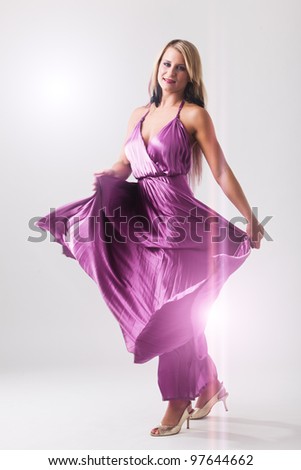 Portrait of a dancing woman with purple dress in motion