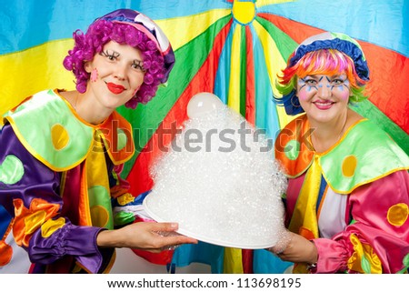 Clowns are making fun on colorful background