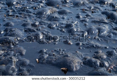 A close up of the surface of black oil pollution.