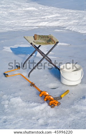 A winter fishing on ice, equipment: auger, camp-chair, ladle, mittens, bucket and rod.