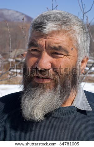 A portrait close-up of the old men with grey beard. Small indigenous people of Russian Far East.