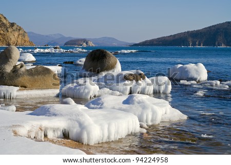 A landscape on winter sea, water, stones and ice.