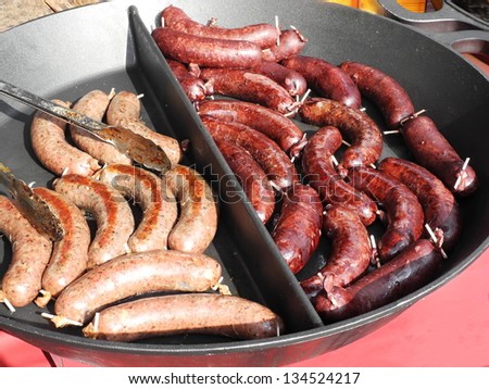 Sausage and hail fried black pudding in a large pan.