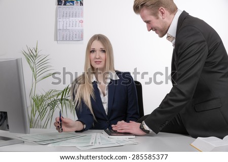 man harasses a woman at desk