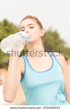 young sports woman is drinking mineral water for refreshment