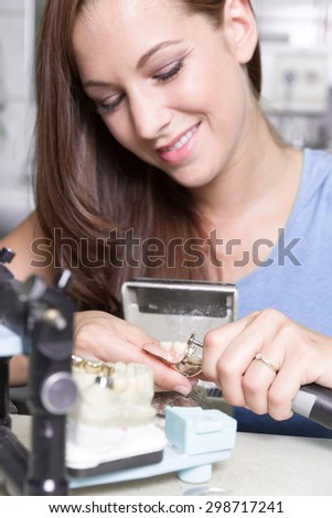 a young woman smiles at work at dental laboratory