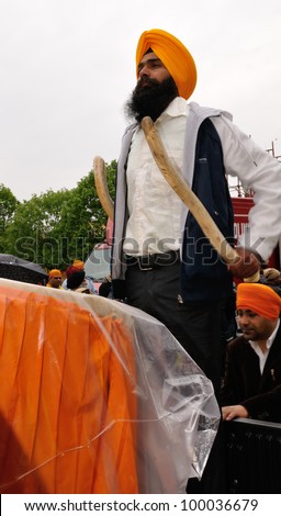 BRESCIA ITALY - APRIL 14: Sikh drummer beats his drum on a pickup truck at the Baisakhi (harvest) Sikh festival, on April 14, 2012 in Brescia